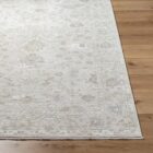 Neutral traditional rug in soft beige and cream with an all-over floral pattern and subtle distressed detailing.
