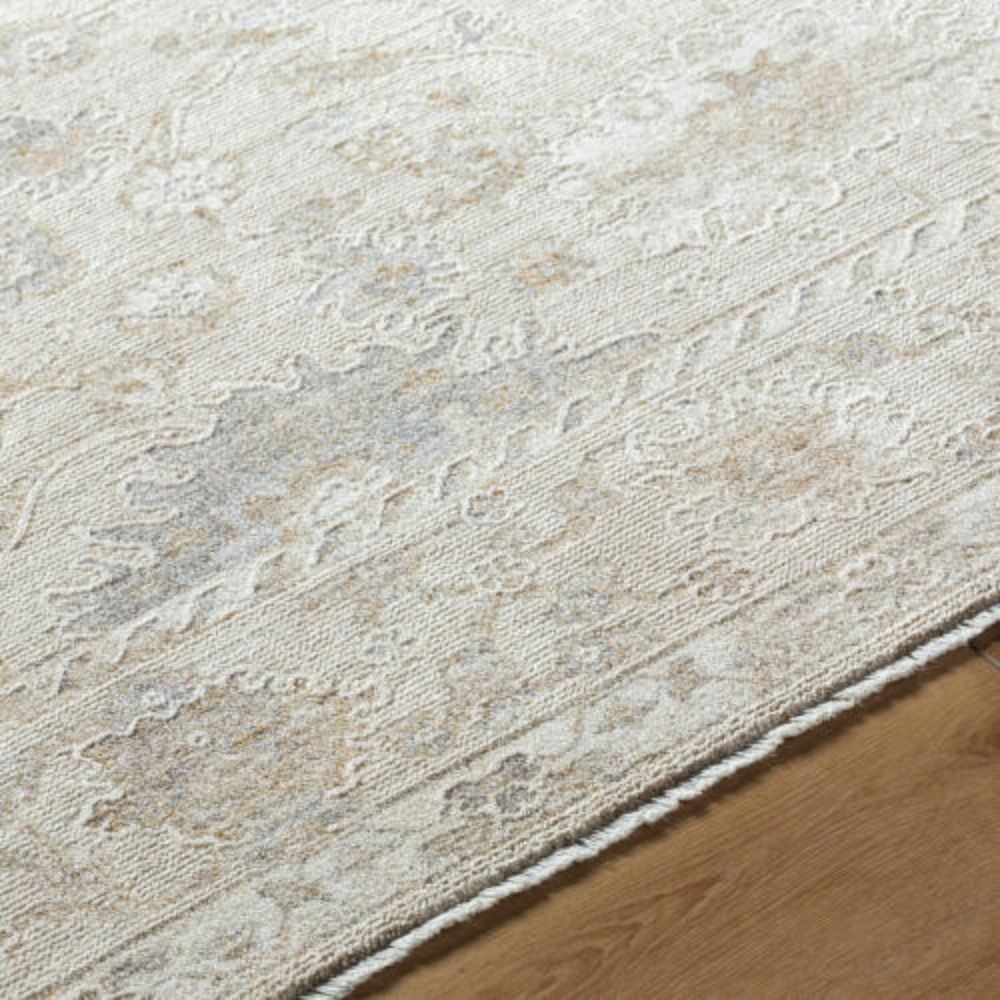 Neutral traditional rug in soft beige and cream with an all-over floral pattern and subtle distressed detailing.