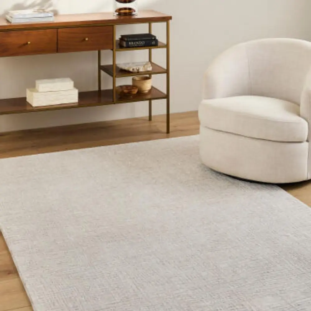 Neutral machine woven rug with subtle tonal texture in soft beige and ivory.