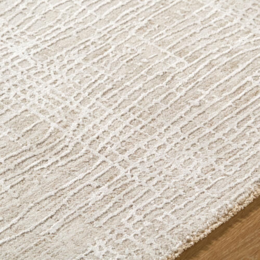 Neutral machine woven rug with subtle tonal texture in soft beige and ivory.