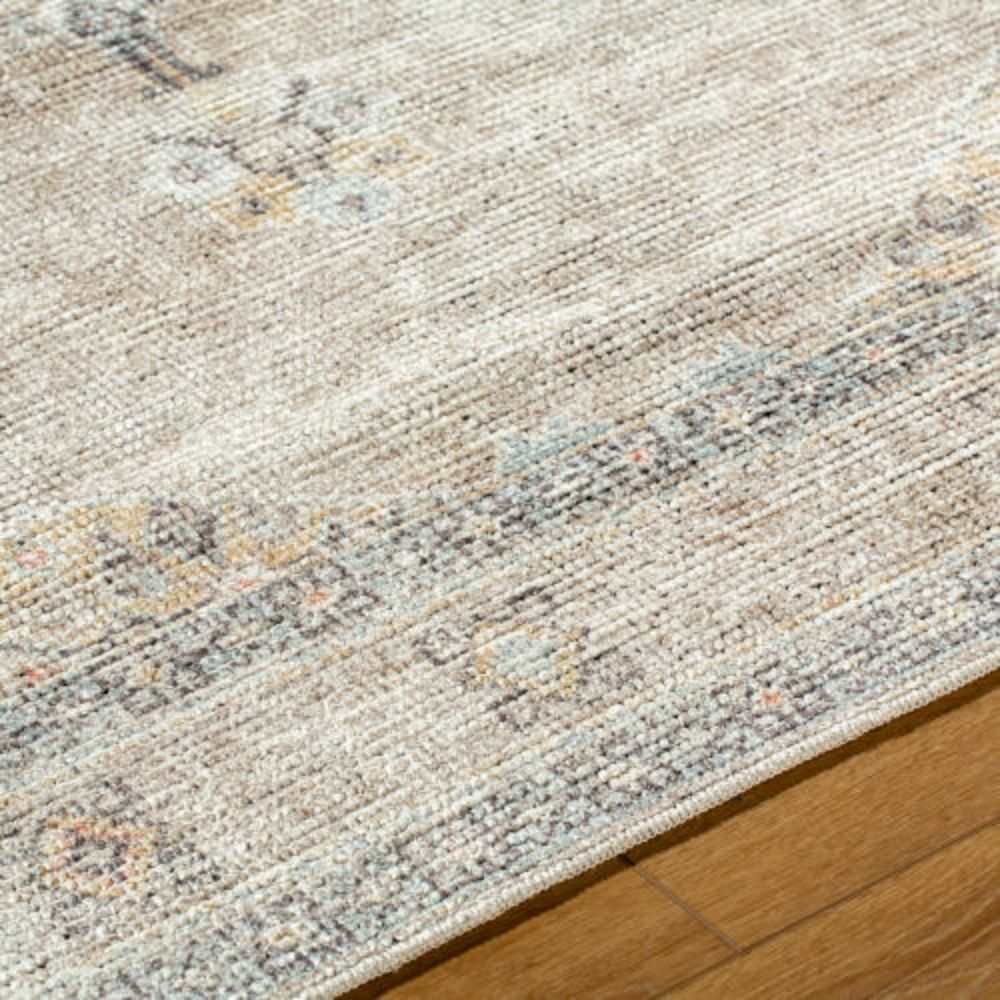 Faded traditional rug in beige, cream, and grey with a central medallion and distressed border.