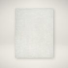 Beige and ivory machine woven rug with a soft medallion and distressed traditional pattern.