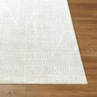 Ivory machine woven rug with subtle tonal texture and minimalist design.