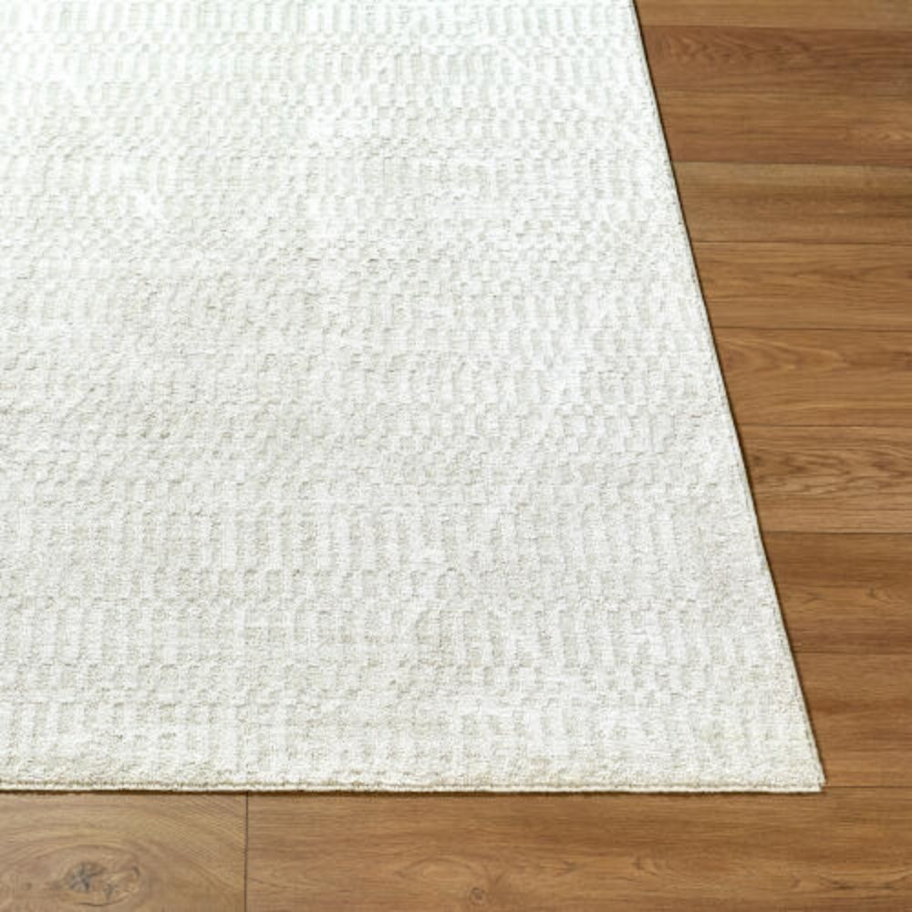 Ivory machine woven rug with subtle tonal texture and minimalist design.