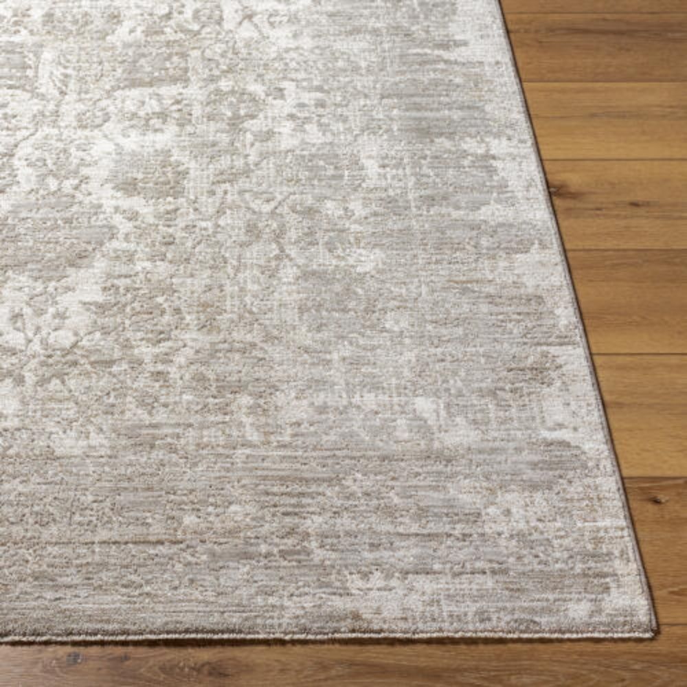 Neutral woven rug with a subtle distressed floral medallion pattern in beige and ivory tones.