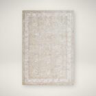 Beige and ivory rug with subtle floral motifs and a delicate bordered pattern.