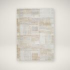 Neutral patchwork-style machine woven rug with geometric linear patterns in beige, taupe, and ivory.
