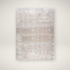 Neutral traditional area rug with soft distressed patterns in beige, ivory, and grey tones.