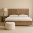 A rustic modern panel bed with a woven wood lattice headboard and a solid wood footboard in a natural weathered finish.