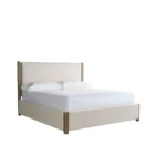 A contemporary upholstered bed in soft beige fabric with a tall padded headboard and natural wood trim accents on the corners and legs.