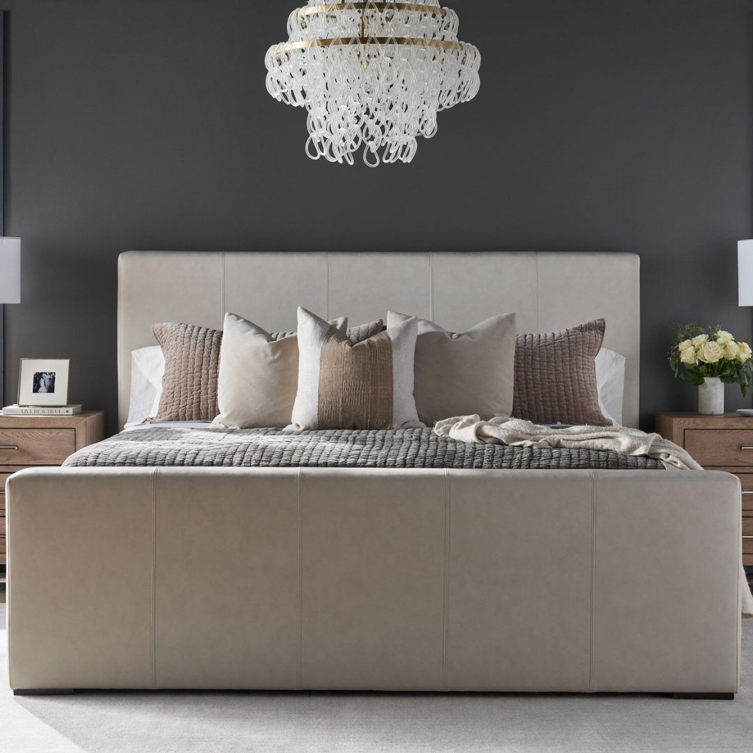 A modern upholstered bed in a soft beige fabric with clean lines, a low-profile footboard, and a tall rectangular headboard.