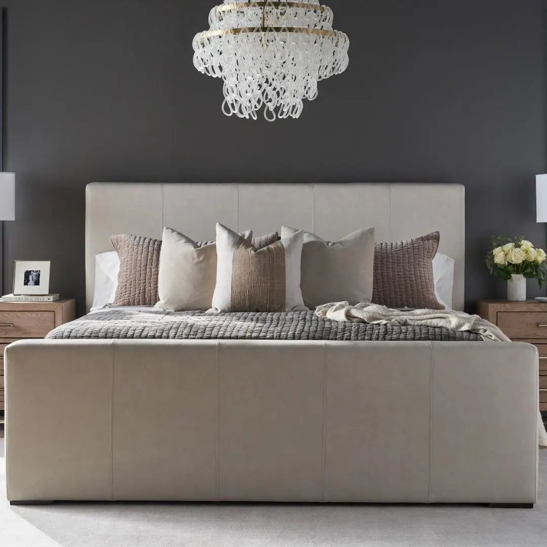 A modern upholstered bed in a soft beige fabric with clean lines, a low-profile footboard, and a tall rectangular headboard.