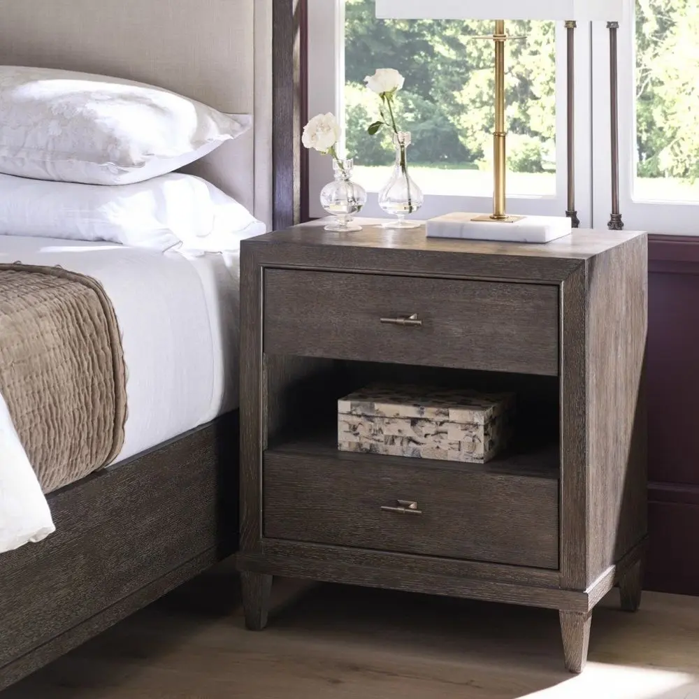A 28-inch wide cocoa-finished nightstand with two drawers, an open center shelf, bronze hardware, and tapered legs.