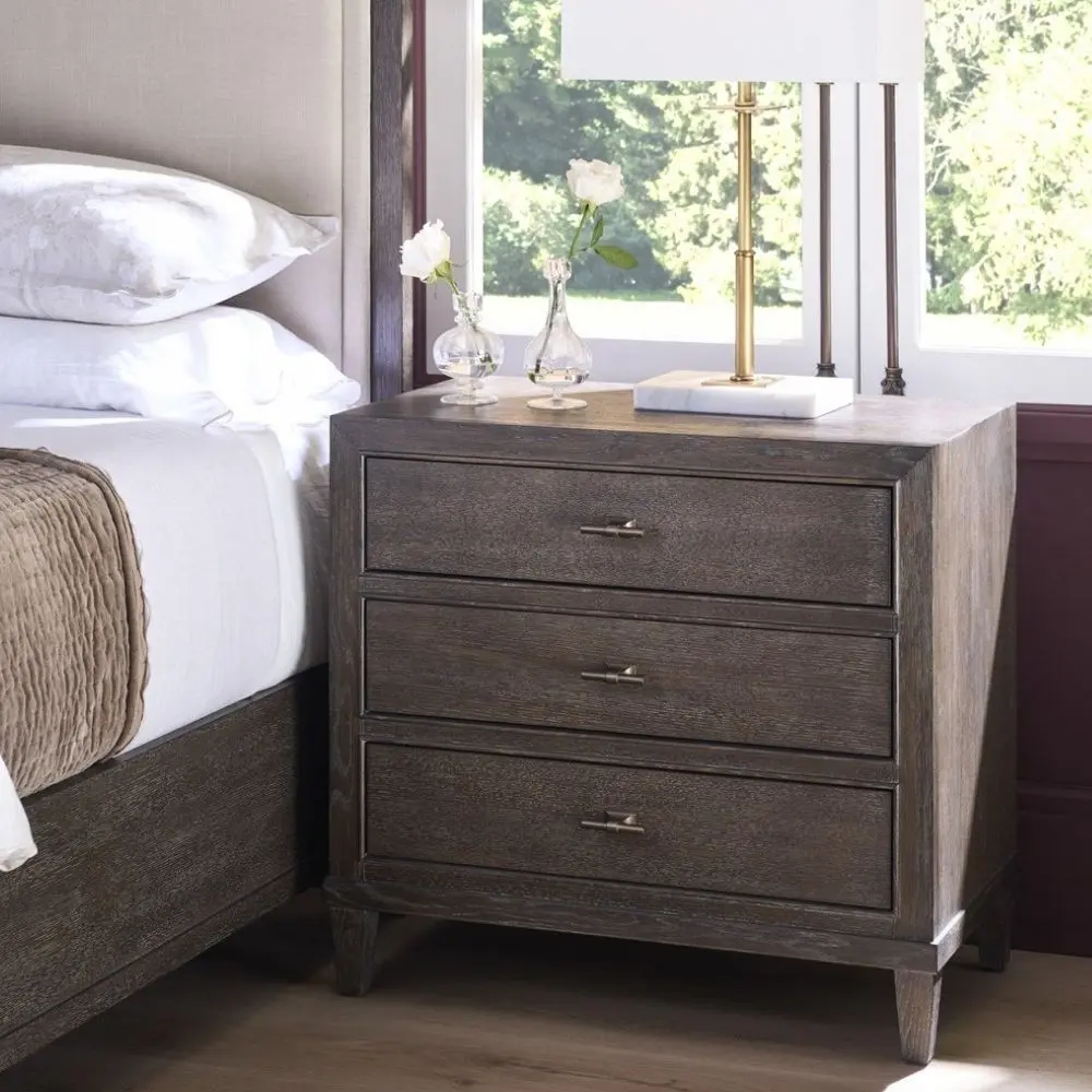 A 32-inch wide dark cocoa-finished nightstand with three drawers, bronze hardware, and tapered legs.
