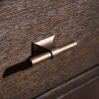 A nine-drawer dresser in a rich cocoa brown wood finish with textured grain, slim brass hardware, and tapered legs.