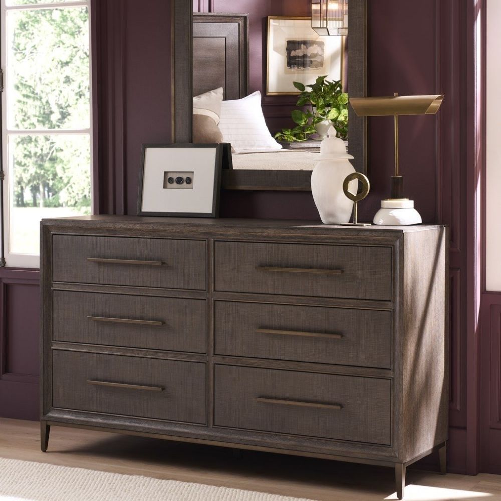A six-drawer dresser in a dark textured wood finish with long horizontal brass handles and slim tapered legs.