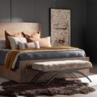 Modern bench with plush taupe cushion and sculptural black arched base.