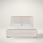 A contemporary upholstered bed with soft cream fabric panels framed by light natural wood, featuring rounded corners and a modern profile.