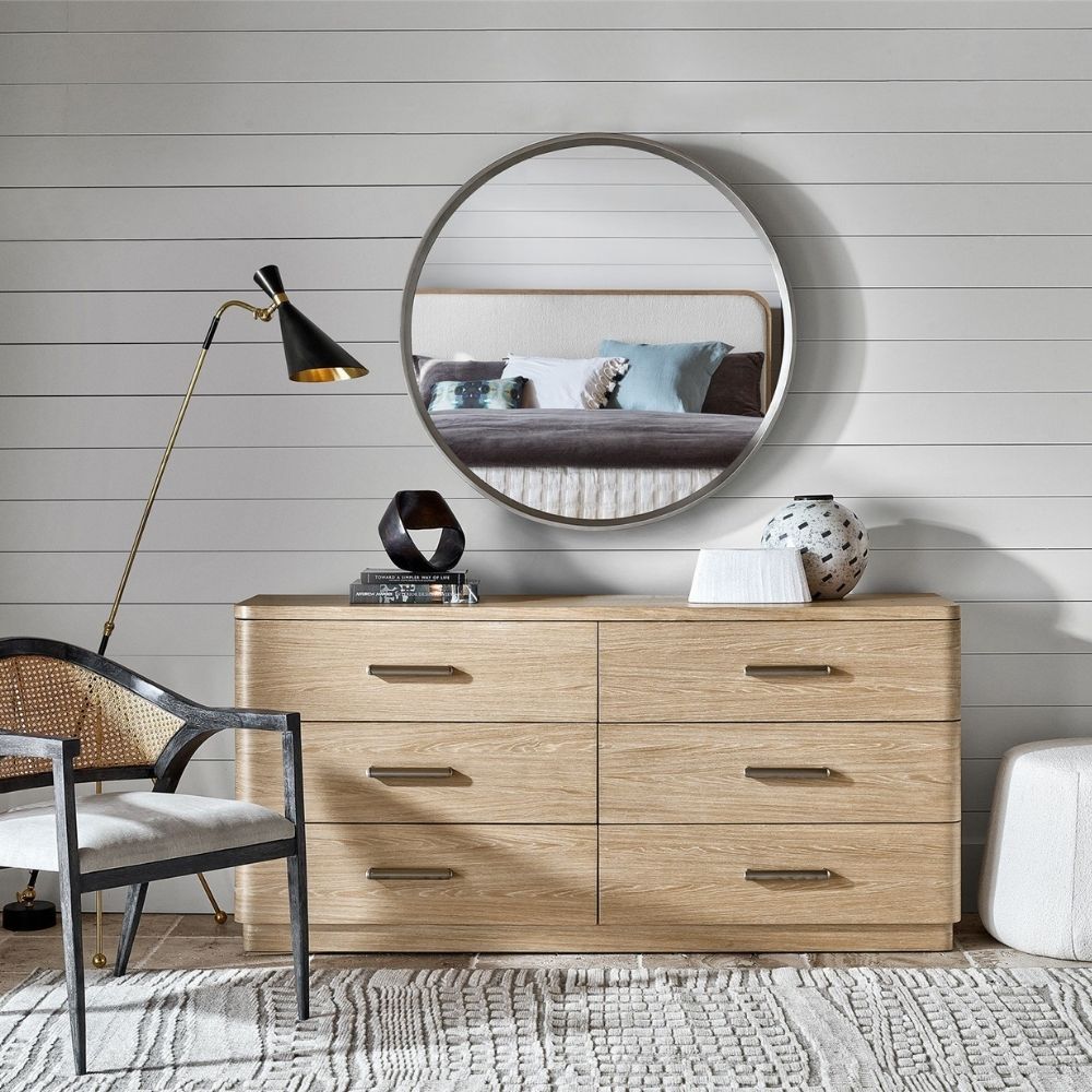 A modern six-drawer dresser in a light natural wood finish with clean lines and sleek silver hardware.