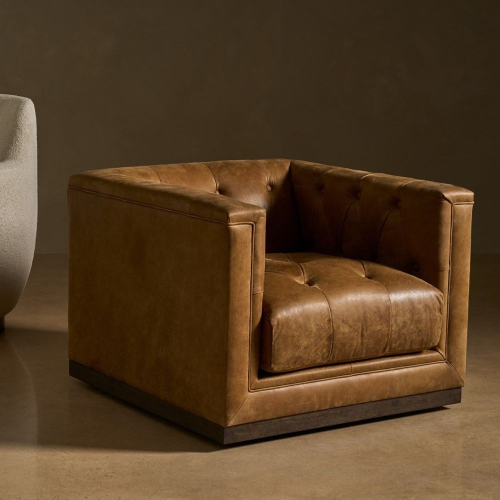Square tufted leather swivel chair with deep seat and modern silhouette.