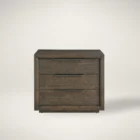 A dark wood nightstand with three drawers, slim black metal handles, and a bold plinth base for a modern grounded look.