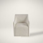 Contemporary upholstered dining chair in soft neutral fabric with clean lines, low arms, and a fully skirted base.