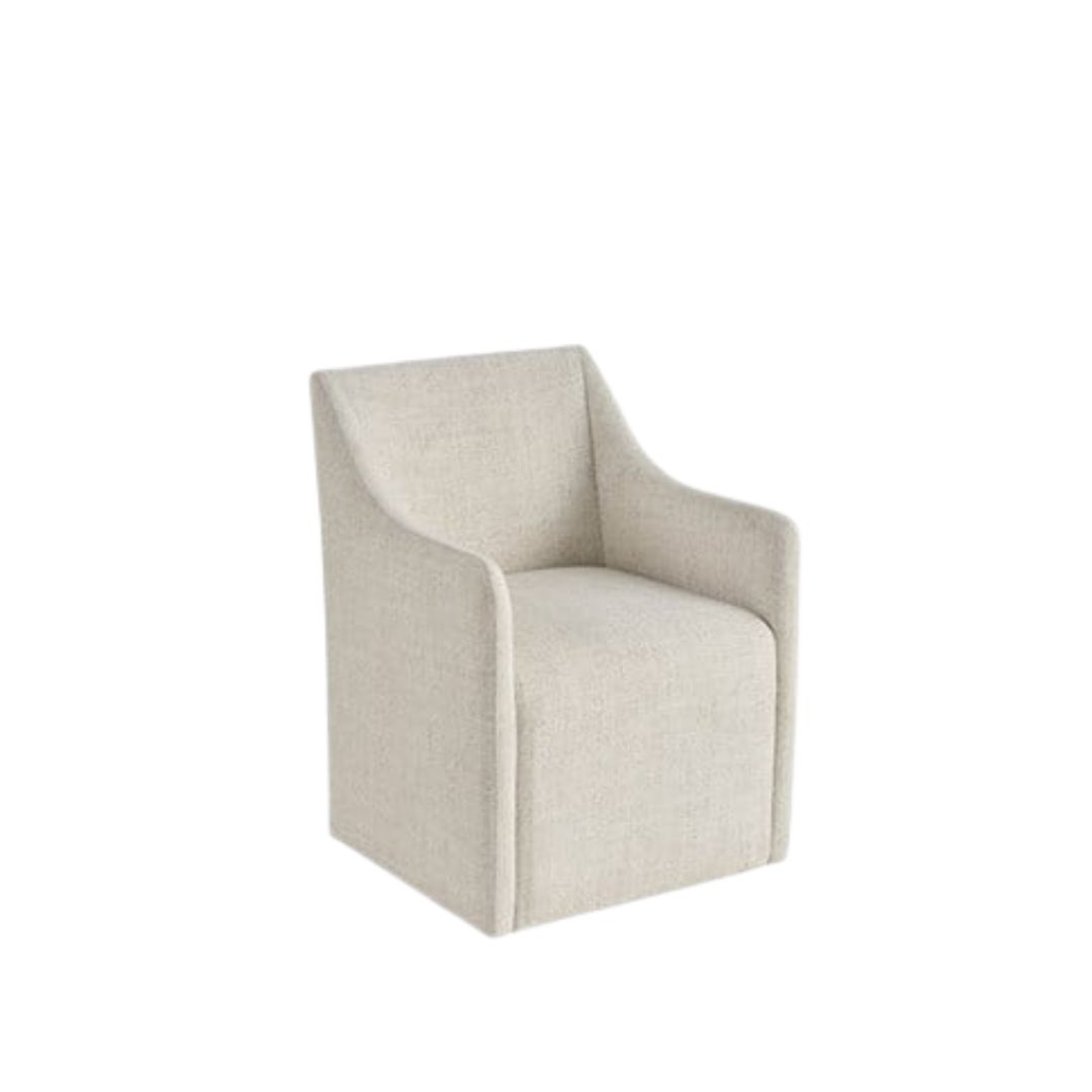 Contemporary upholstered dining chair in soft neutral fabric with clean lines, low arms, and a fully skirted base.