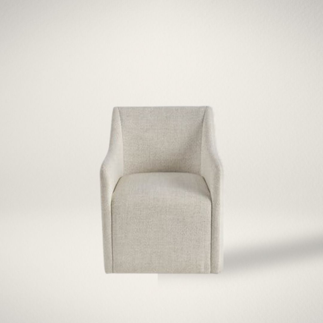 UN WALSH DINING CHAIR Contemporary upholstered dining chair in soft neutral fabric with clean lines, low arms, and a fully skirted base.