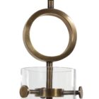 Modern sconce with a clear glass cone shade, antique brass accents, and an exposed bulb design.