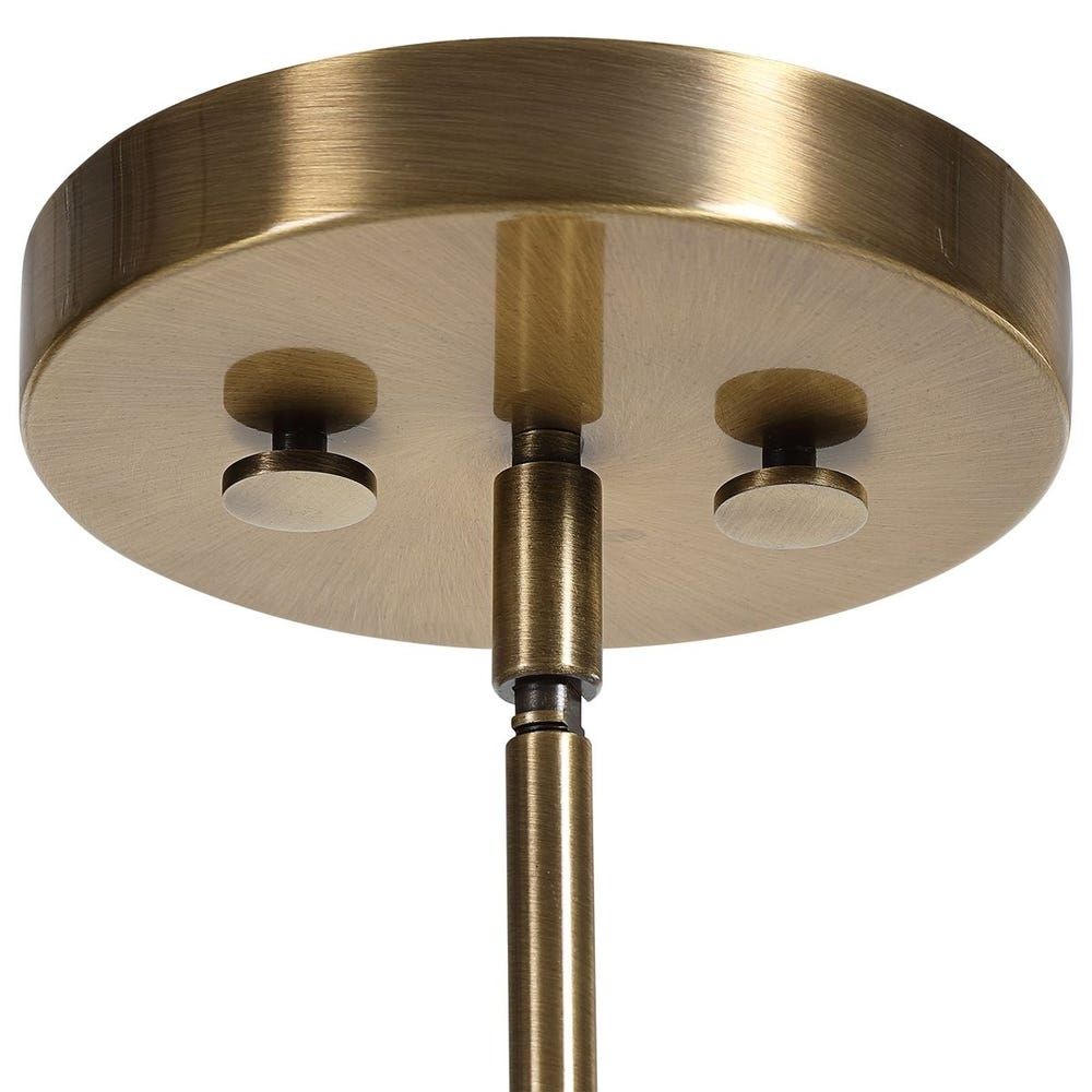 Modern sconce with a clear glass cone shade, antique brass accents, and an exposed bulb design.