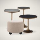Round beige pouf with textured upholstery and rounded black feet.