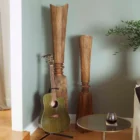Tall handcrafted wooden sculpture with natural grain and geometric carved detailing.