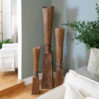 Tall handcrafted wooden sculpture with natural grain and geometric carved detailing.