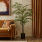 Artificial palm plant with tall green fronds in a black pot.
