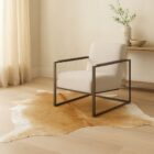 Natural beige cowhide rug with soft neutral tones and an organic freeform shape.