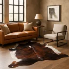 Natural brindle cowhide rug featuring deep brown and black tones with a striking white backbone and organic edges.