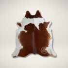 Natural brown and white cowhide rug with soft, organic shape and smooth finish.