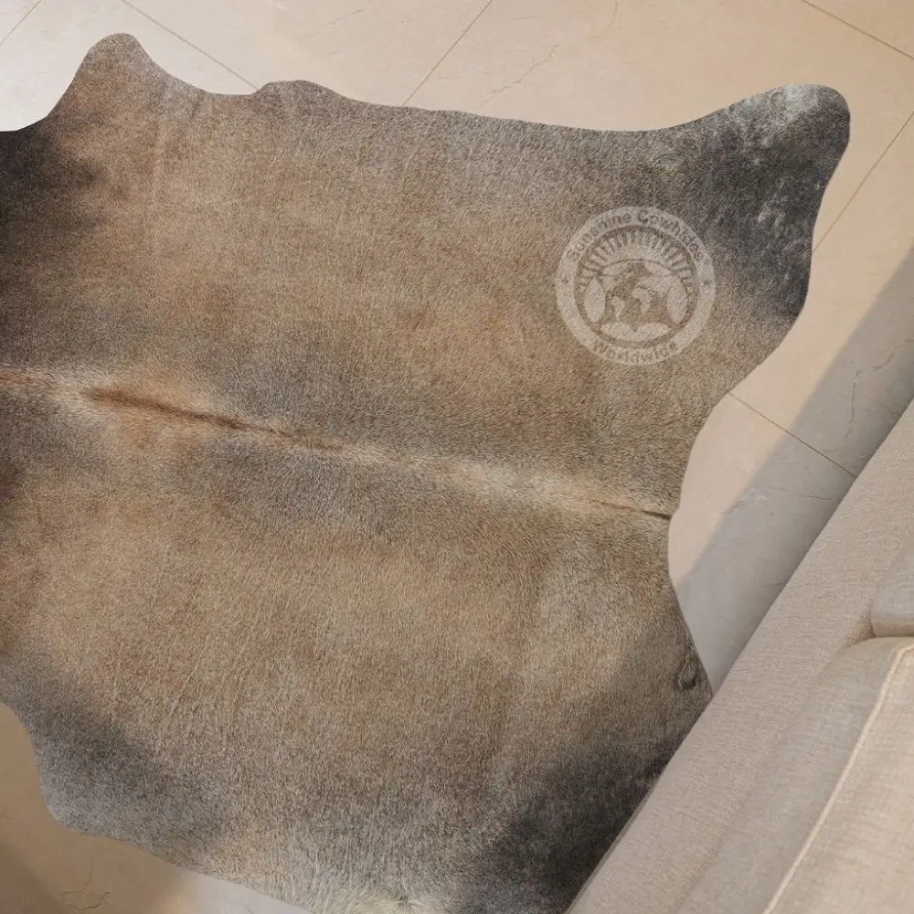 Natural grey-beige cowhide rug featuring soft neutral tones and organic shape.