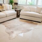 Natural champagne cowhide rug with soft neutral sheen and organic shape.