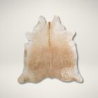 Natural light beige cowhide rug with smooth texture and soft tonal variations.