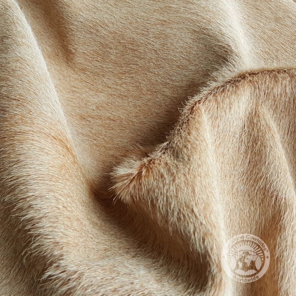 Natural light beige cowhide rug with smooth texture and soft tonal variations.
