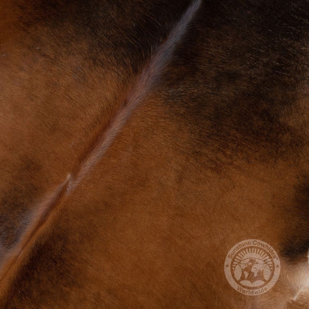 Natural mahogany brown cowhide rug featuring rich tones and a soft, organic silhouette.
