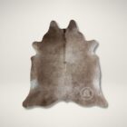 Natural taupe cowhide rug with unique organic shape and soft neutral tones.