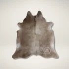 Natural taupe cowhide rug with unique organic shape and soft neutral tones.