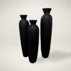 Set of three tall black sculptural vases with matte finish and flared openings in graduated sizes.