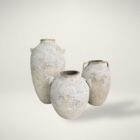 Set of three large handcrafted vases with a distressed, textured white finish and classic Mediterranean-inspired shapes.
