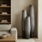 Set of three tall grey sculptural vases with ombré finish and elongated silhouettes.