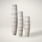 Set of three tall sculptural vases in soft grey and ivory tones with a smooth gradient finish and elongated cylindrical shapes.