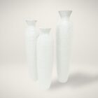 Set of three tall white sculptural vases with a hand-textured matte finish and flared openings in graduated sizes.