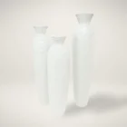 Set of three tall white sculptural vases with a hand-textured matte finish and flared openings in graduated sizes.
